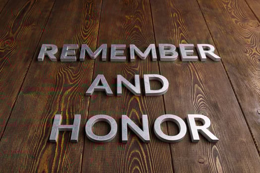 words remember and honor laid with silver metal letters on wooden background photo