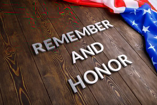 words remember and honor laid with silver metal letters on wooden background with USA flag on the right side photo