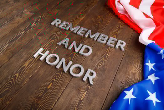 words remember and honor laid with silver metal letters on wooden background with USA flag on the right side photo