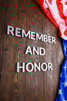words remember and honor laid with silver metal letters on wooden background with USA flag on the right side photo