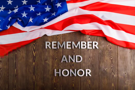 words remember and honor laid with silver metal letters on wooden background with USA flag above photo