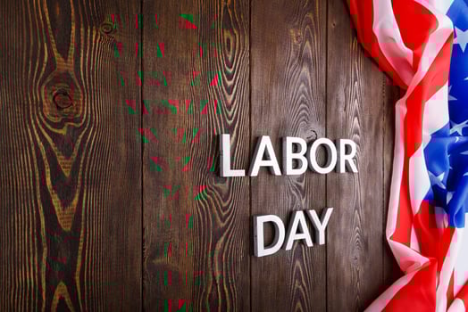 words labor day laid with silver metal letters on wooden surface with crumpled USA flag on left side photo