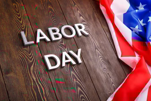 words labor day laid with silver metal letters on wooden surface with crumpled USA flag on left side photo