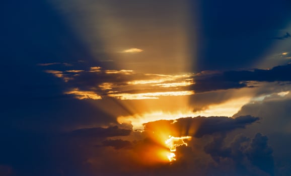cloudy sunset sky with yellow sun rays without horizon photo