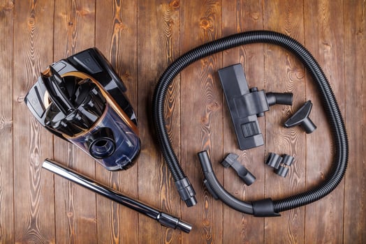 cheap cyclone type bagless vacuum cleaner with spare parts on wooden background in high angle directly above view photo