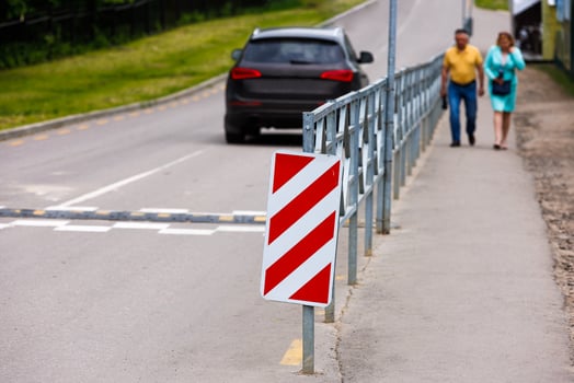 red and white diagonal striped sign at road fence end photo