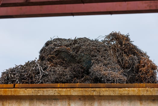 pile of metal swarf on blue sky background, close-up photo
