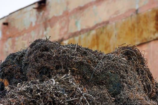 pile of metal swarf on dirty concrete wall background, close-up photo