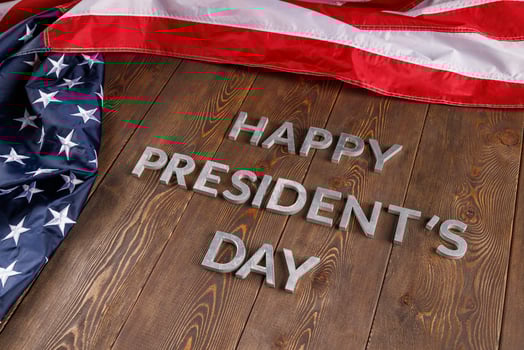 words happy presitdents day laid with real letters on wooden board near US flag photo
