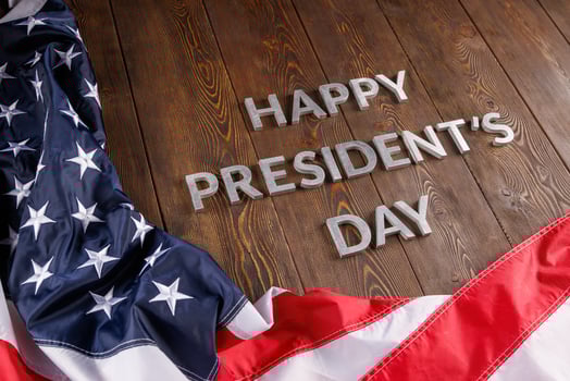 words happy presitdents day laid with real letters on wooden board near US flag photo