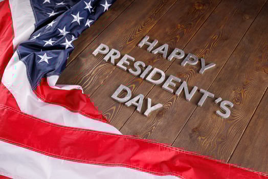 words happy presitdents day laid with real letters on wooden board near US flag photo