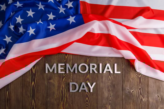 the words memorial day laid with silver metal letters on wooden board surface with crumpled usa flag photo
