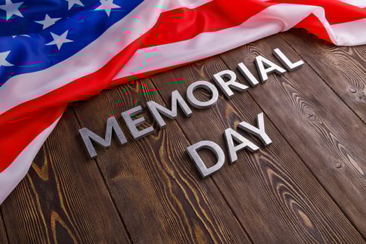the words memorial day laid with silver metal letters on wooden board surface with crumpled usa flag photo