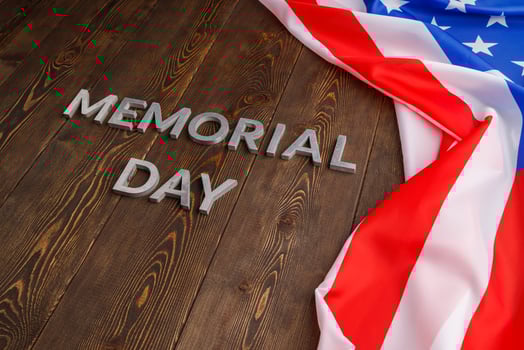the words memorial day laid with silver metal letters on wooden board surface with crumpled usa flag photo