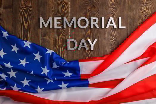 the words memorial day laid with silver metal letters on wooden board surface with crumpled usa flag photo