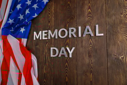the words memorial day laid with silver metal letters on wooden board surface with crumpled usa flag photo