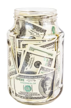 A hundred US dollars bank notes in a glass jar isolated on white background photo