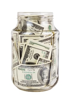 A hundred US dollars bank notes in a glass jar isolated on white background photo