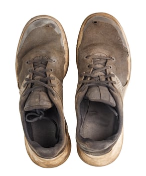 a pair of weared dirty sneakers isolated on white background, flat lay vew from above photo