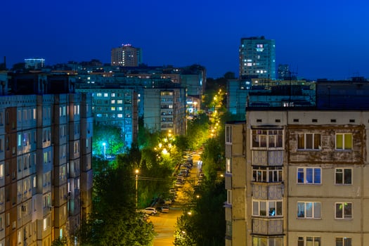Windows, roofs and facade of an mass apartment buildings in Russia at summer night. photo