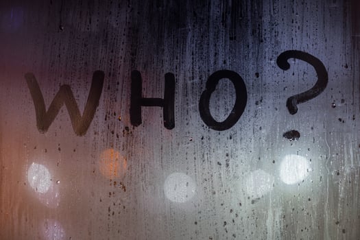 the question who written by finger on night wet glass with blurred lights in background photo