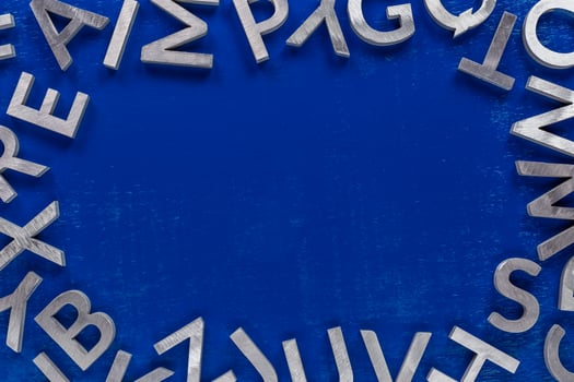 Frame mockup made of of silver metal english alphabet characters on blue background. photo