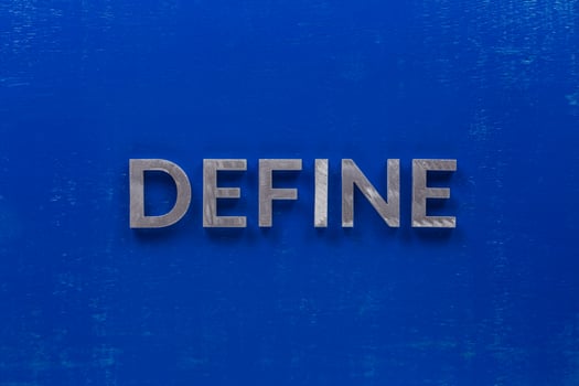 the word define laid on blue painted board with thick silver metal capital letters photo