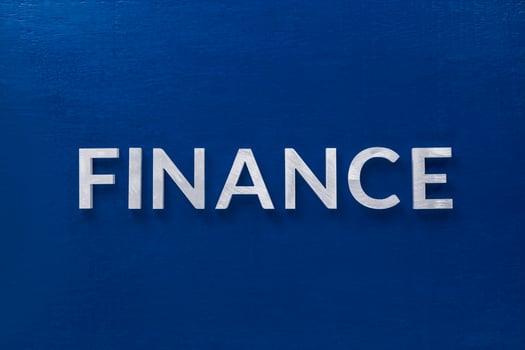 the word finance laid with silver metal letters on classic blue board in flat lay with central composition photo