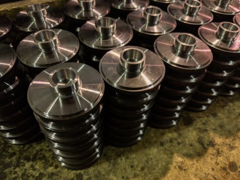 stacks of batch production round parts in a wooden box photo
