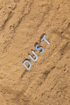 the word dust on dusty road surface in flat lay perspective photo
