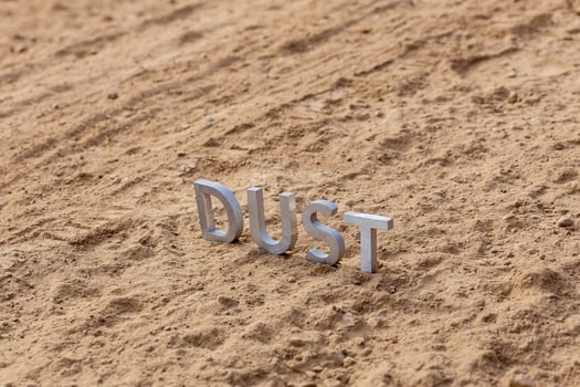 the word dust standing on dusty road surface in linear perspective photo