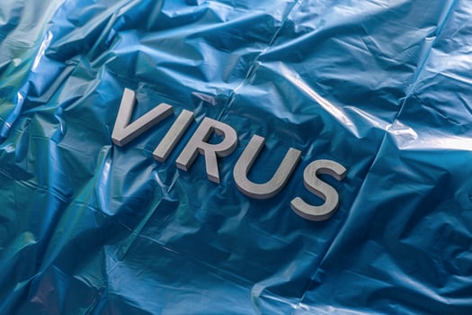 the word virus laid with silver metal letters on crumpled blue plastic film with dramatic light photo