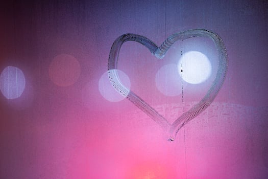 heart symbol hand drawn on wet night window glass in pink colors photo