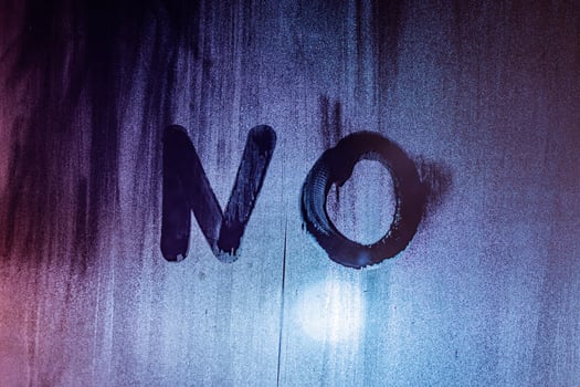 the word no handwritten on night wet window glass surface photo