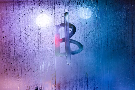 bitcoin symbol - handwritten on wet glass of night window photo
