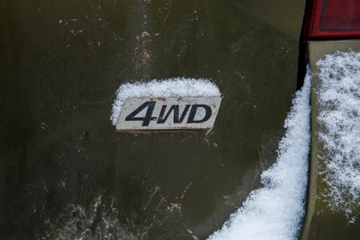 an abbreviation 4wd - Four-wheel drive - on dirty green car back photo