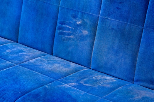 dusty blue sofa surface with palm prints closeup with selective focus photo