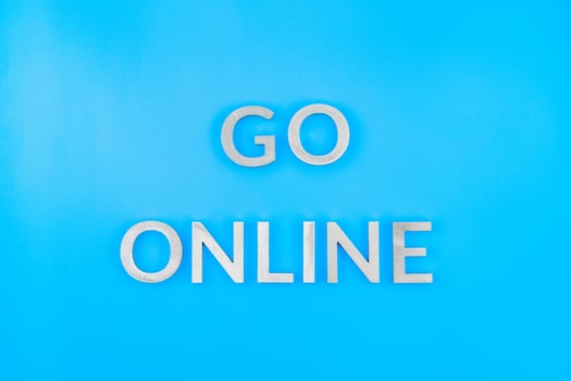the words go online laid with brushed aluminium letters on blue flat surface - close-up with flat lay composition photo