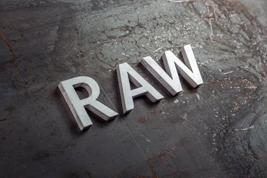the word raw laid with silver metal letters on hot rolled steel sheet surface in diagonal perspective photo