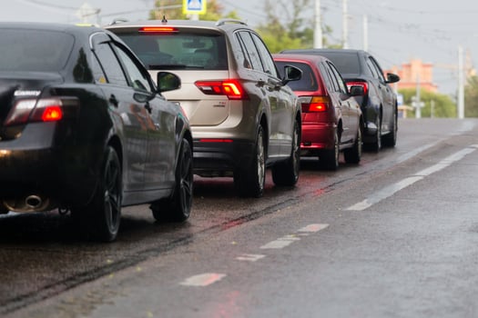 TULA, RUSSIA JULY 6, 2019 Cars on summer road stopped before crossroads after rain. Selective focus telephoto shot. photo