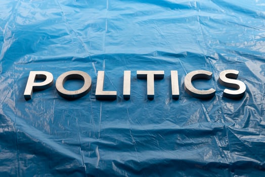 the word politics laid with silver aluminium letters over crumpled plastic blue film background - in center of picture photo