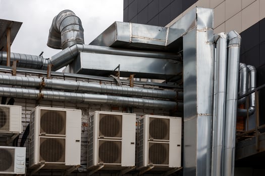 old outdoor ventilation air ducts and air conditioners outside of back wall of cafe kitchen photo