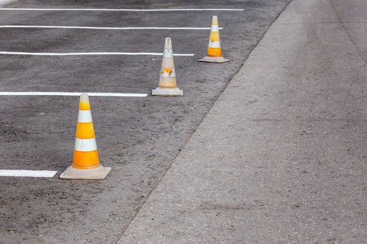 Orange road cones on a asphelt driving area with white lines photo