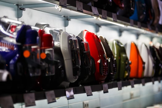 row of domestic vacuum cleaners on shelf of household appliances store photo