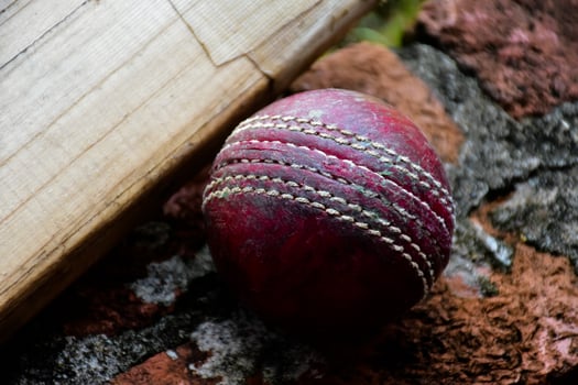 Cricket sport equipments on brick, bat, wicket, old leather ball, soft and selective focus. photo
