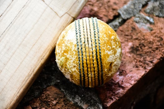 Cricket sport equipments on brick, bat, wicket, old leather ball, soft and selective focus. photo