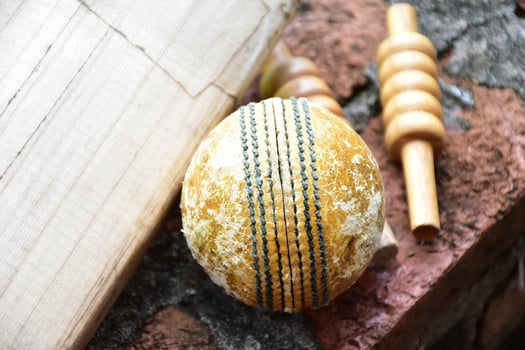 Cricket sport equipments on brick, bat, wicket, old leather ball, soft and selective focus. photo