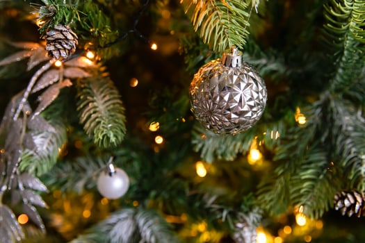 Classic Christmas decorated New year tree. Christmas tree with white and silver decorations, ornaments toy and ball. Modern classical style interior design apartment. Christmas eve at home. photo