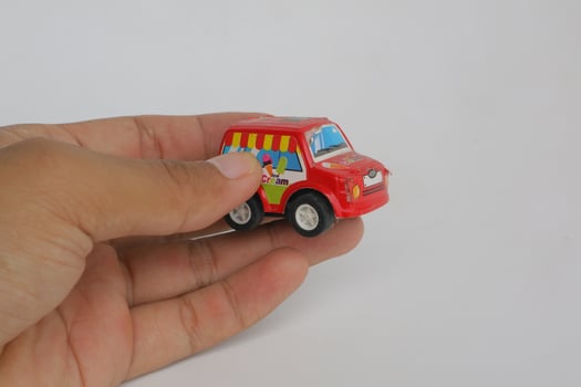Semarang, Indonesia - December 03, 2021, hand holding red toy car on white background photo