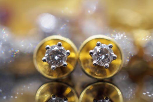 Luxury gold Jewelry diamond earrings with reflection on black background photo